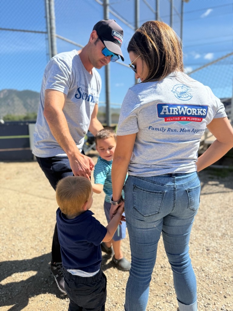 Kevin, Stephanie, and their children wearing AirWorks shirts at a community event