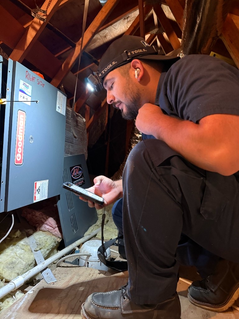 AirWorks technician diagnosing a residential furnace and reviewing system readings