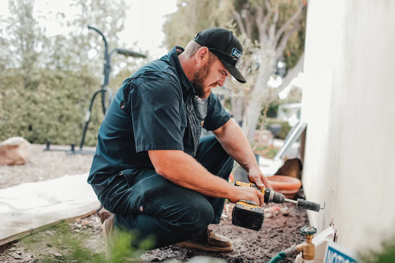 AirWorks technician servicing a residential air conditioning condenser