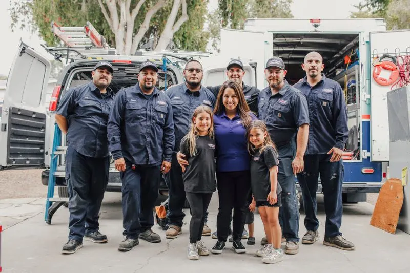 The full AirWorks crew and family gathered in front of open service vans